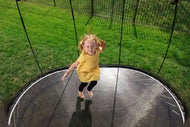 Load image into Gallery viewer, a young girl jumping on a trampoline