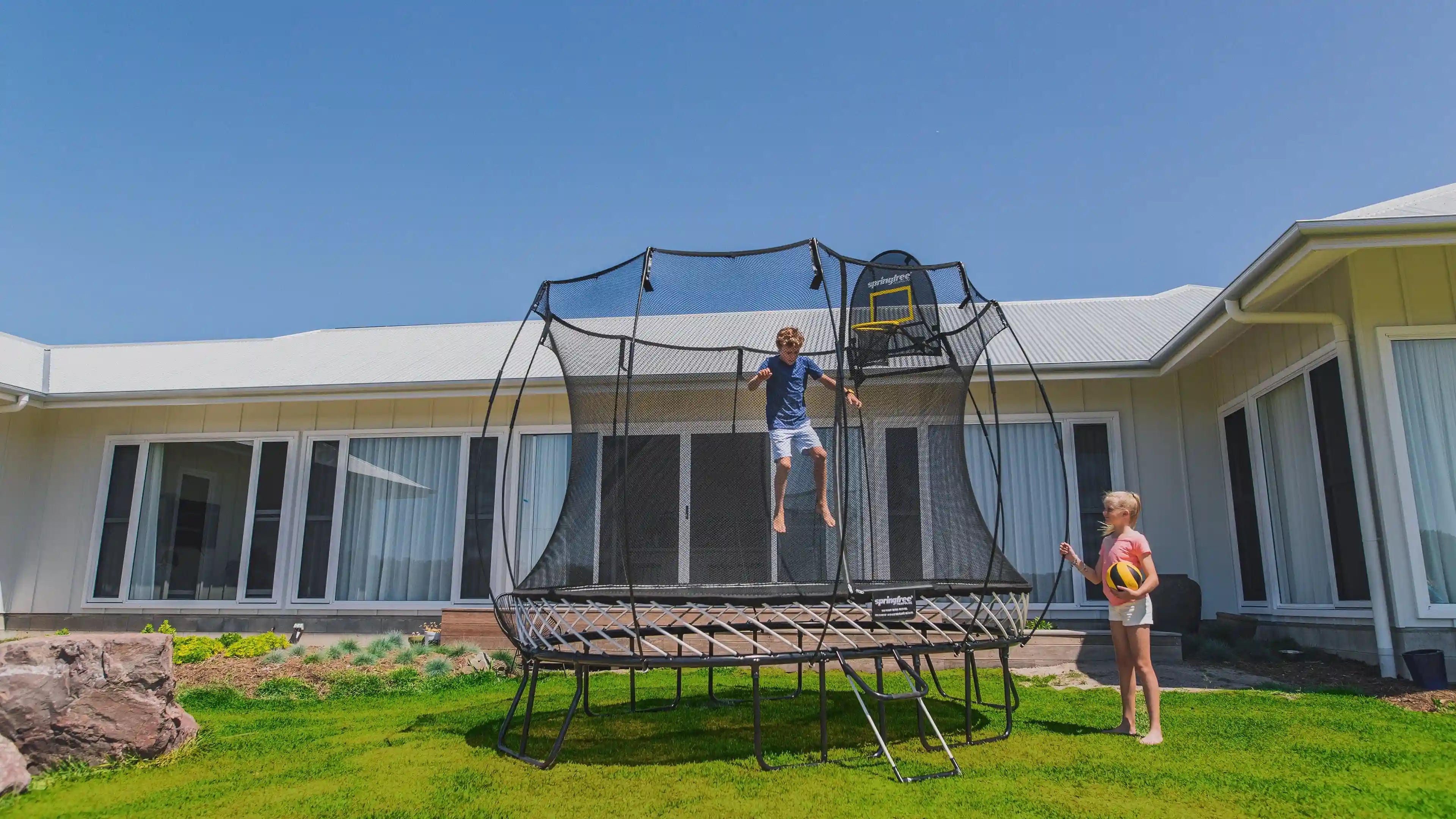 Kids playing basketball on an outdoor trampoline