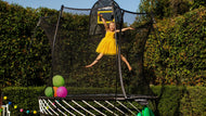 Load image into Gallery viewer, A girl jumping high on a trampoline
