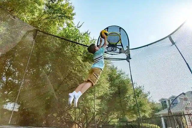 young boy playing basketball with a springfree trampoline ball