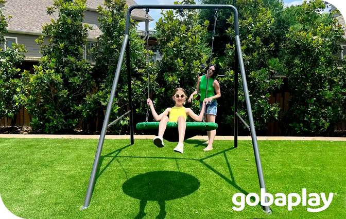 a young girl being pushed in the swing by a lady