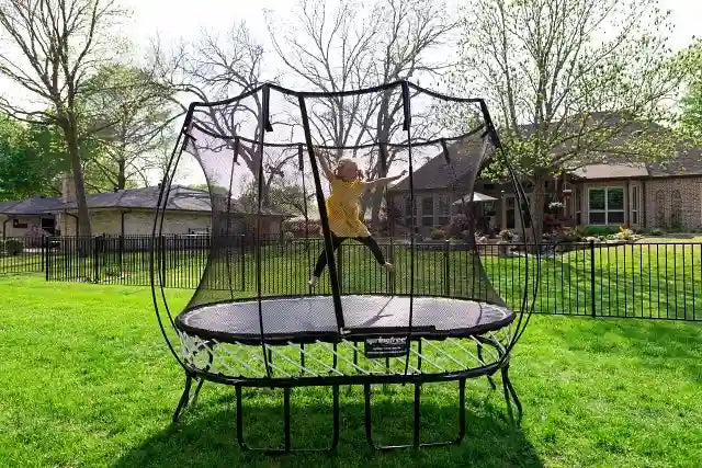 a young girl jumping high on a trampoline