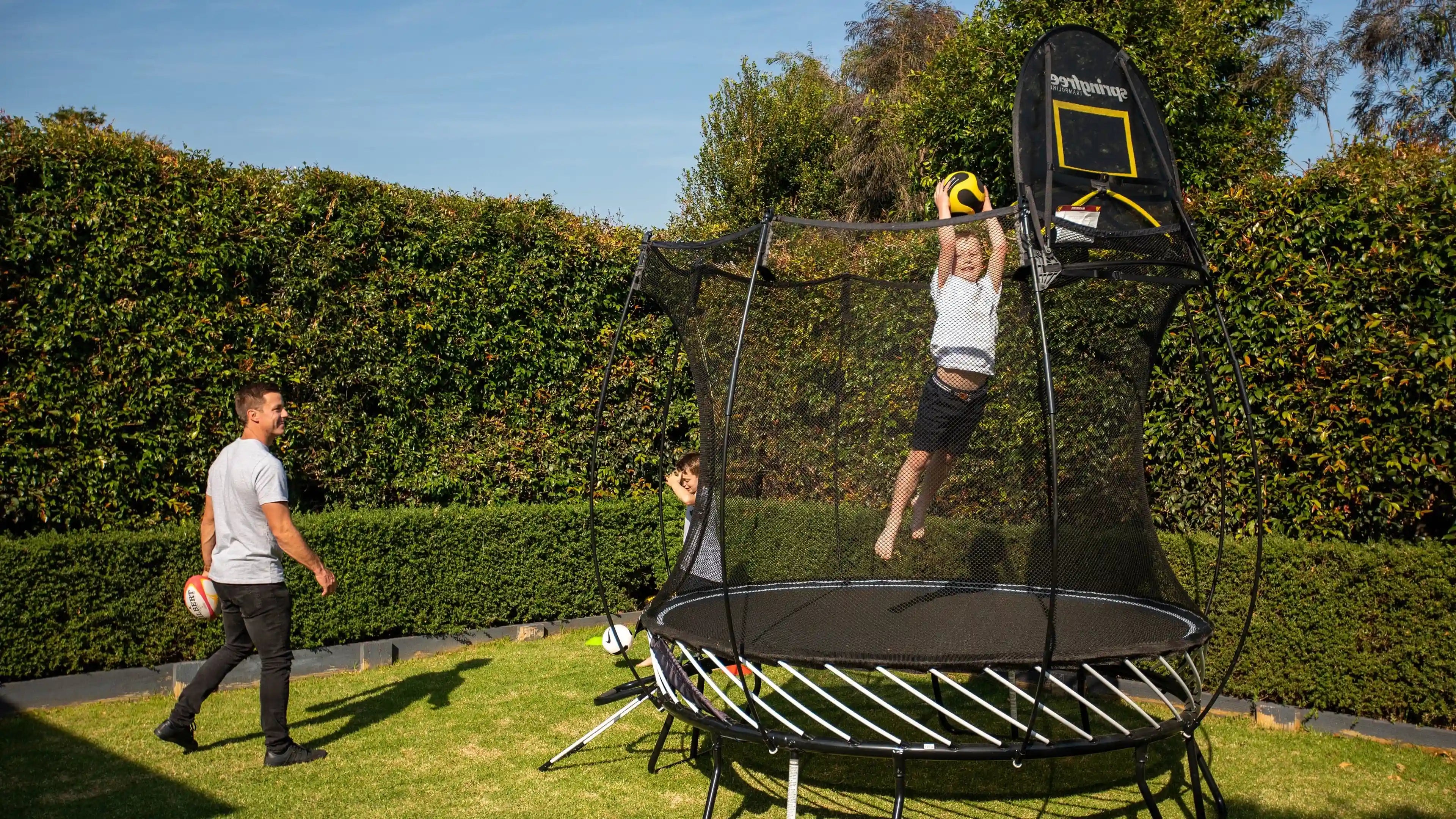 Boy dunking on hoop attached to Trampoline