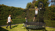 Load image into Gallery viewer, Boy dunking on hoop attached to Trampoline
