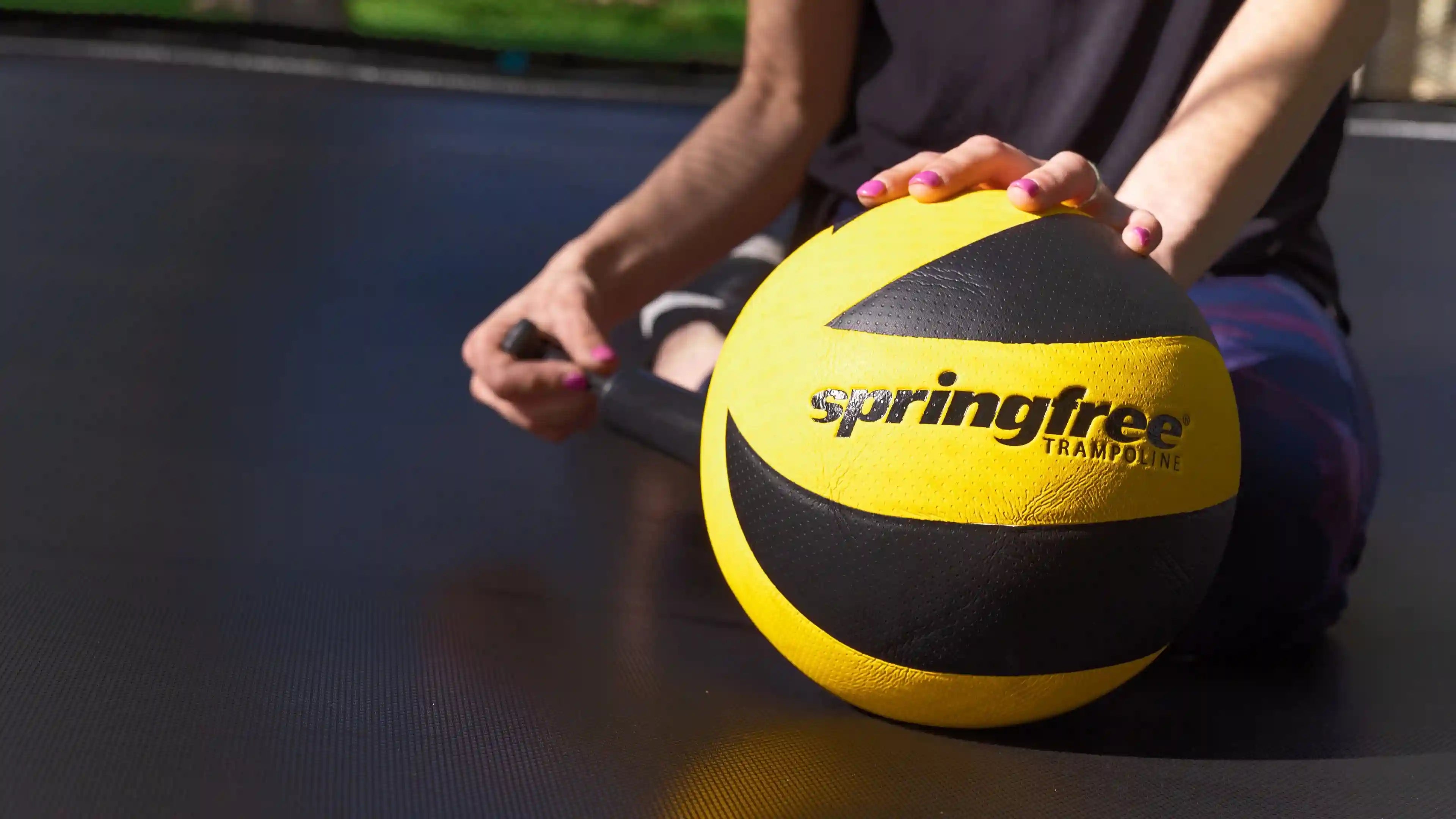 lady pumping a springfree trampoline ball